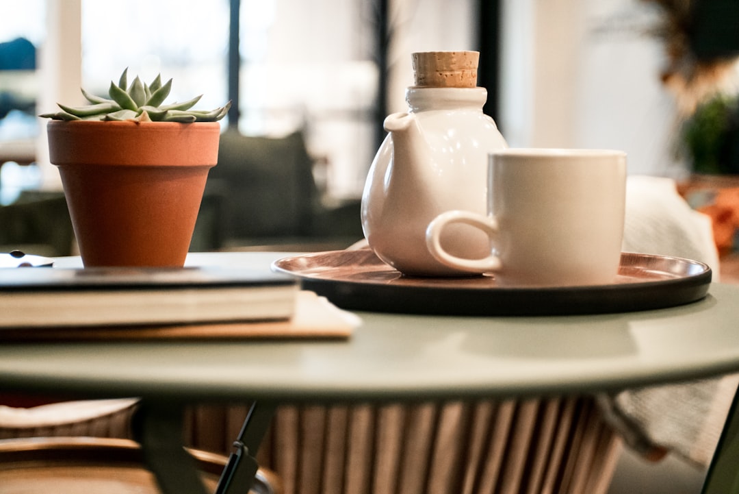 About white-cup-beside-teapot-on-tray-ilfok7ntmgs